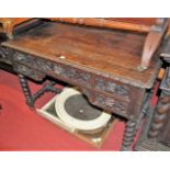 An early 20th century heavily carved oak kneehole writing table, having five Green Man mask carved