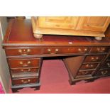 A contemporary oak topped and mahogany twin pedestal writing desk, having a rexine inset writing