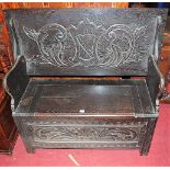 A circa 1900 ebonised and line carved oak fold-over monks bench, having typical hinged box seat base