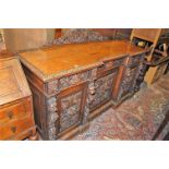 A good late 19th century heavily carved oak inverted breakfront ledgeback sideboard having three '