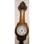 An early 20th century carved oak aneroid two dial wheel barometer