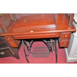 An early 20th century Federation sewing machine table, having hinged compartment and cast iron base,