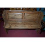 A contemporary stained pine two panelled three seater church pew, width 138.5cm