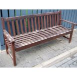 A modern stained and slatted teak three-seater garden bench, width 189cm