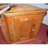 A pine hanging corner cupboard; together with a faux crocodile skin suitcase (2)