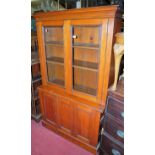 A late Victorian small oak bookcase cupboard, having twin glazed upper doors, w.93cm