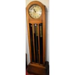 An Art Deco oak long case clock, having a silvered circular dial with three train movement, glazed