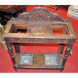 A circa 1900 line carved oak ledge back twin division stick stand, width 76cm