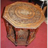 A circa 1900 heavily relief carved oak octagonal two-tier centre table, raised on turned columns,