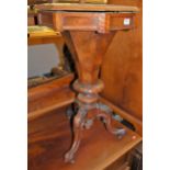 A mid-Victorian figured walnut octagonal hinge-top sewing table, raised on floral carved hipped