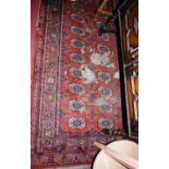 A Persian woollen red ground Bokhara rug (ground heavily worn), 226x170cm; together with one other