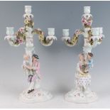 A pair of late 19th century Sitzendorf porcelain four-light candelabra, each modelled as a seated