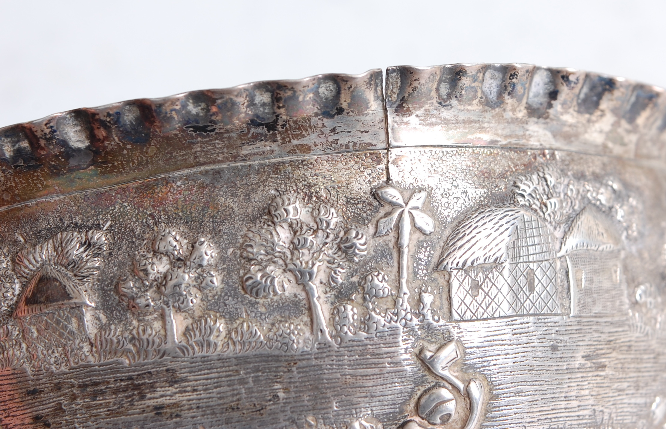 A circa 1900 Chinese white metal bowl, having a wavy rim above an embossed border depicting - Image 3 of 3