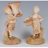 *A pair of Royal Worcester blush ivory figures, the boy in standing pose with a basket upon his