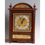 A circa 1900 oak cased mantel clock, the square brass dial having silvered chapter ring, twin