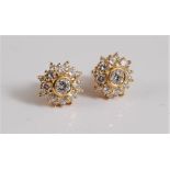 A pair of diamond cluster earrings, the central round brilliant diamond, collet mounted and