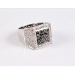 An 18ct black and white diamond ring, the central square panel set with round black diamonds,