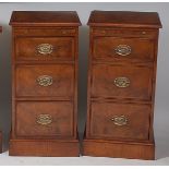 A pair of figured walnut and crossbanded three drawer narrow chests, each with brushing slide, w.