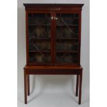 *An Edwardian mahogany bookcase on stand, the upper section having adjustable shelves enclosed by