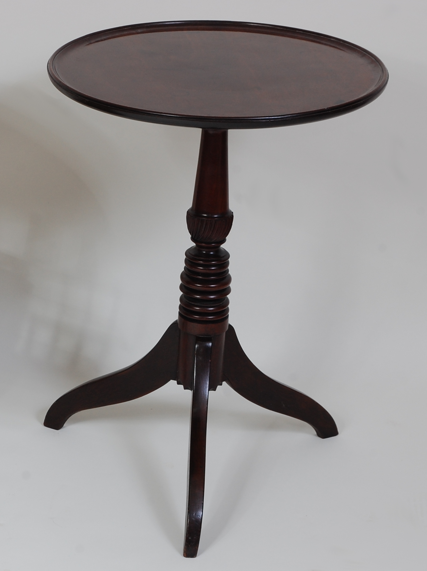 *A Regency mahogany occasional table, the circular dished top on a turned urn column to tripod base,