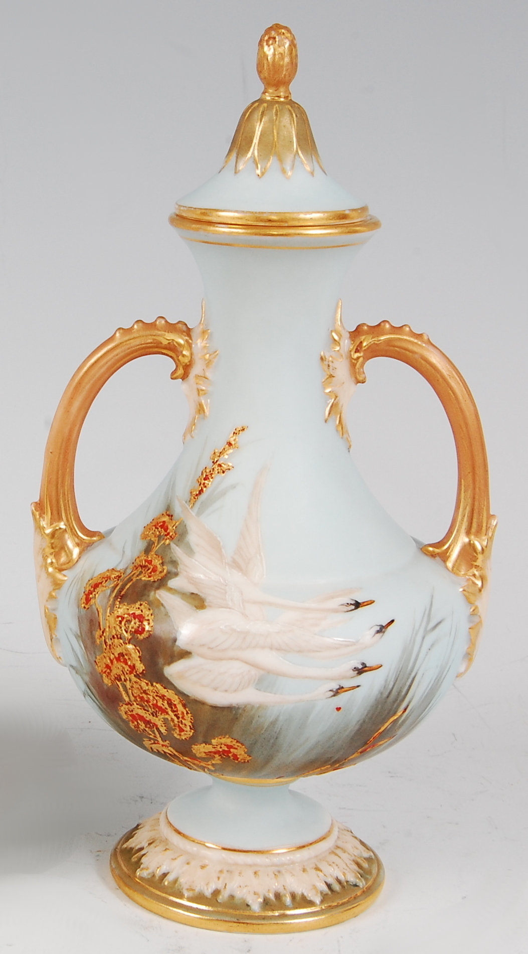 *A Royal Worcester twin handled vase and cover, on a turquoise ground, enamel decorated with swans