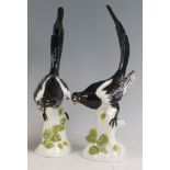 A pair of circa 1900 Dresden porcelain magpies, each modelled upon a treestump with applied