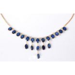 A '21k' sapphire fringe necklace, the oval spectacle set sapphires, each approx. 6.5mm long, (19
