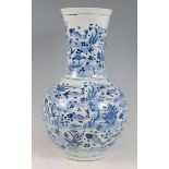 A Chinese export stoneware bottle vase, underglaze blue decorated with fish, seaweed and plants,