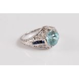 A platinum, zircon, sapphire and diamond ring, the central pale blue zircon, approx. 8mm diameter,