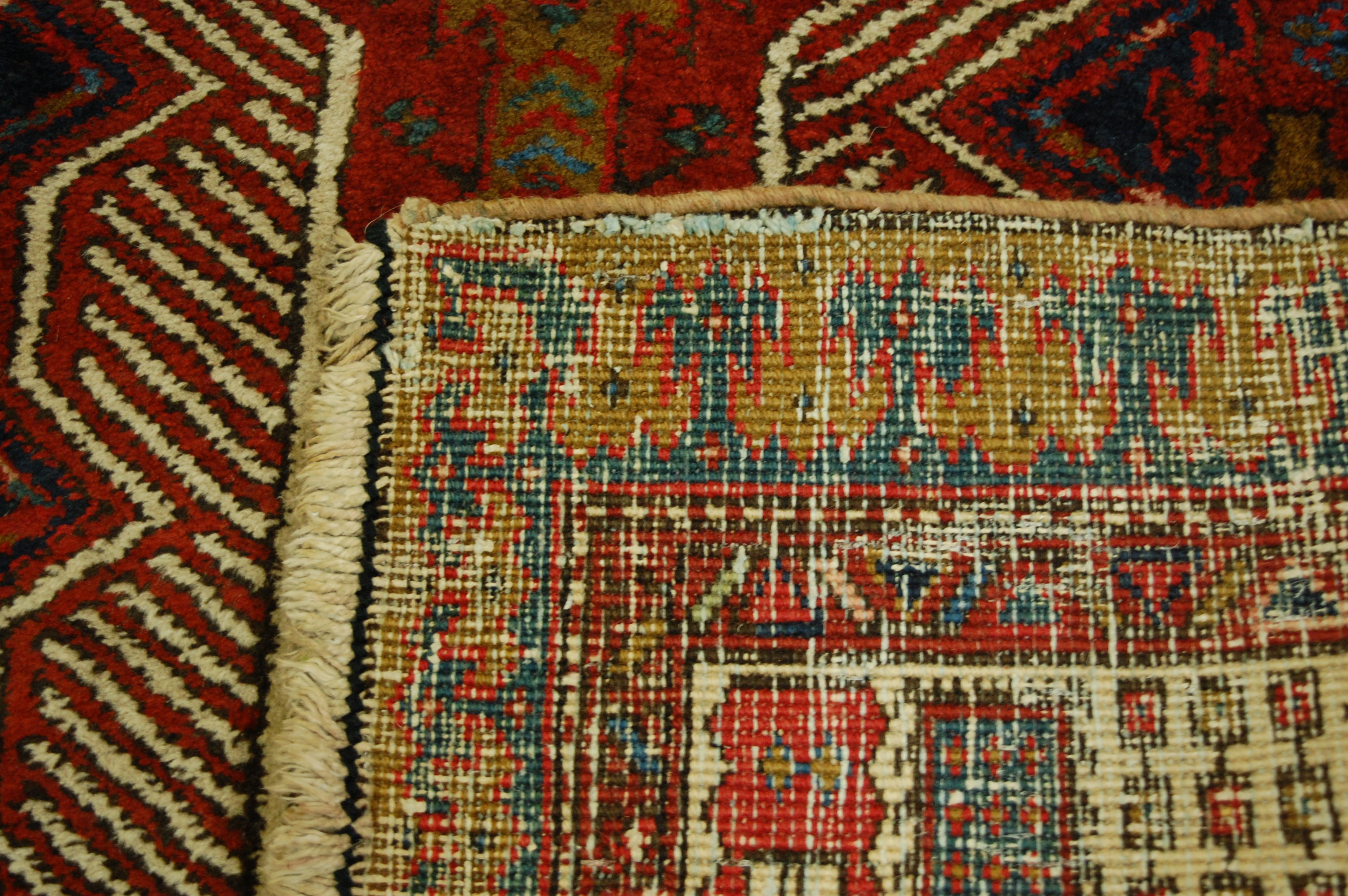 A Persian woollen Sarab rug, having a red ground decorated with central medallion and stylised - Image 2 of 2