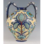 A late 19th century Italian faience twin handled vase, decorated with stylised flowers and foliage