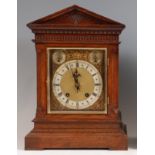 A circa 1900 German oak cased bracket clock, having square brass dial with silver chapter ring,