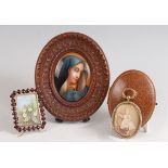 A Continental painted porcelain miniature depicting the Madonna, 8 x 6cm, in carved softwood