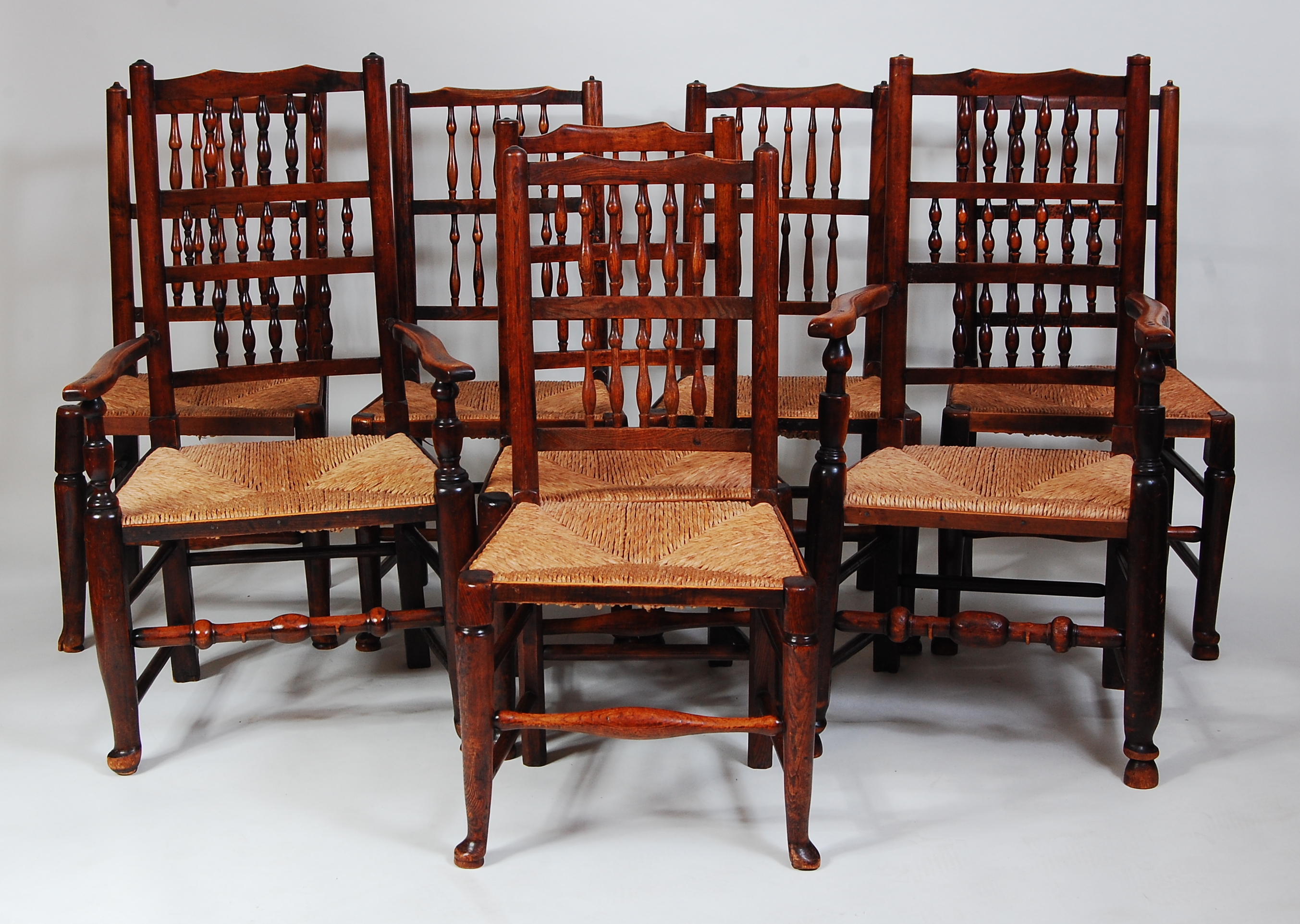 A set of eight Lancashire elm spindleback chairs, each having replacement rush seats, turned