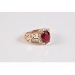 A 14k treated ruby and diamond ring, the oval claw mounted ruby, surrounded by small round diamonds,