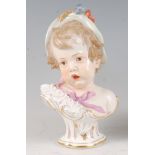 A mid-19th century Meissen porcelain bust, modelled as a young girl wearing a hat with a pink ribbon