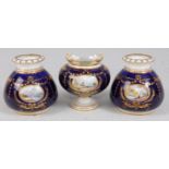 *A Royal Crown Derby three vase garniture, each piece having a central panel painted with a