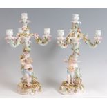 A pair of circa 1900 German porcelain four light candelabra, each modelled as a floral encrusted