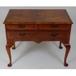 A walnut lowboy, in the 18th century style, the rectangular quarter veneered feather strung top
