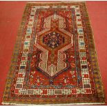 A Persian woollen Sarab rug, having a red ground decorated with central medallion and stylised