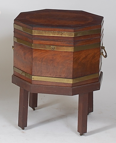 A Regency mahogany celleret, of brass bound octagonal form, the top with fielded oval crossbanded