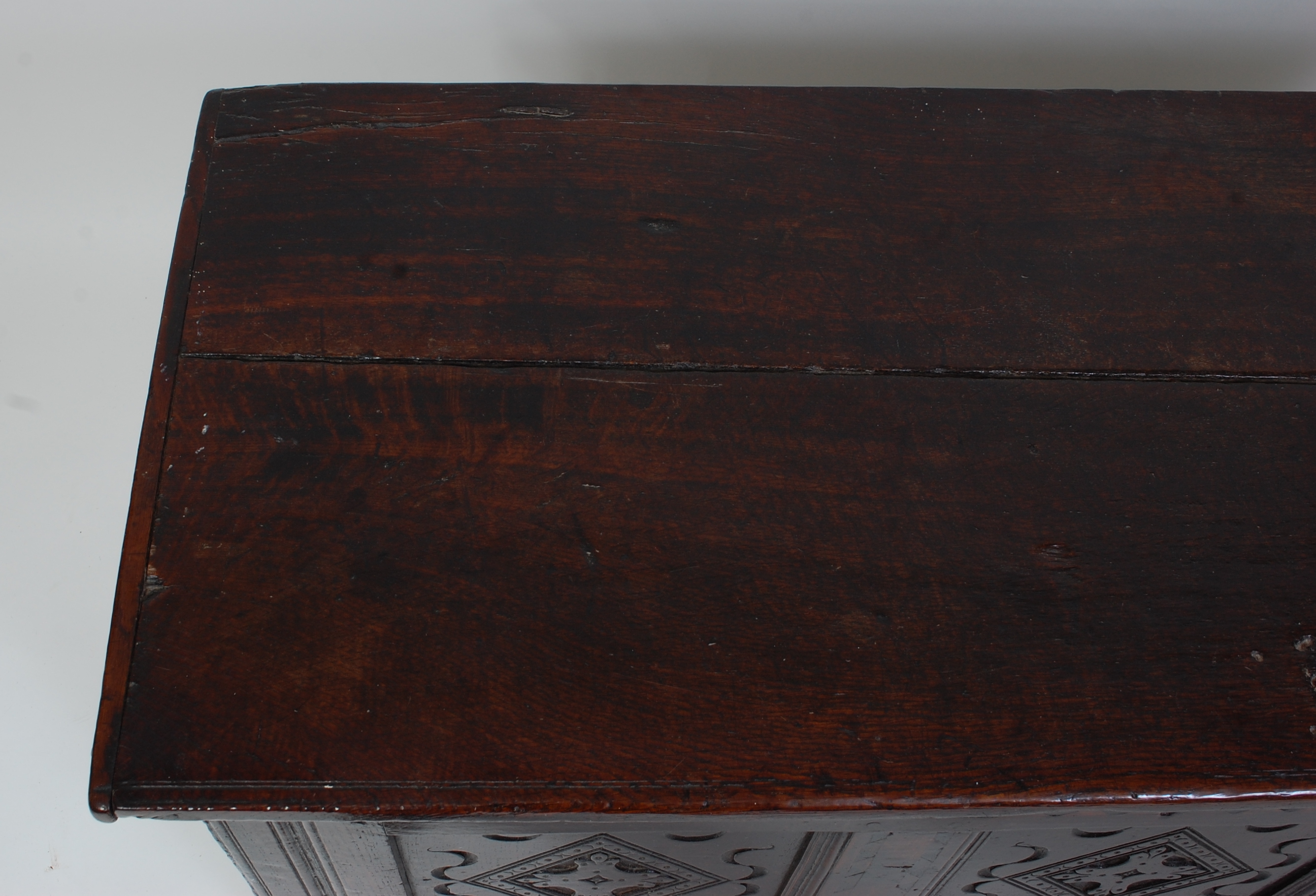 *An 18th century joined oak coffer, the two-plank top on split ring hinges, above a carved three - Image 2 of 6