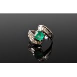 An 18ct emerald and diamond crossover ring, the square cut emerald, approx. 6.5mm square, in a