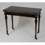 A Victorian ebonised and parcel gilt card table, the fold-over top having a moulded edge, opening to