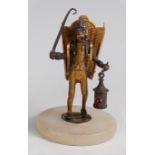 A Victorian novelty match-striker, modelled as monkey lamp-lighter, the basket on his back for