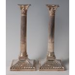 A pair of Victorian silver Corinthian column candlesticks, each having removable sconce to a