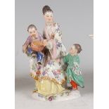 A Meissen porcelain figure of an Oriental mother seated with her two children, she on a floral dress