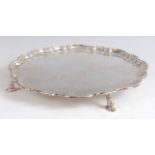 A Mappin & Webb silver salver, having a raised piecrust rim, engraved ground, and on four scroll
