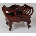 An early Victorian rosewood four division music Canterbury, having carved scroll decoration above