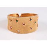 An 18ct gemset hinged cuff bracelet, the satin textured tapered cuff, set with raised stars each